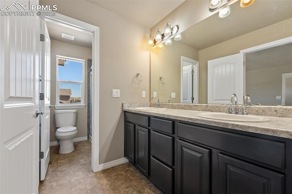 Image 15 of 25: Full bathroom featuring double vanity and toilet