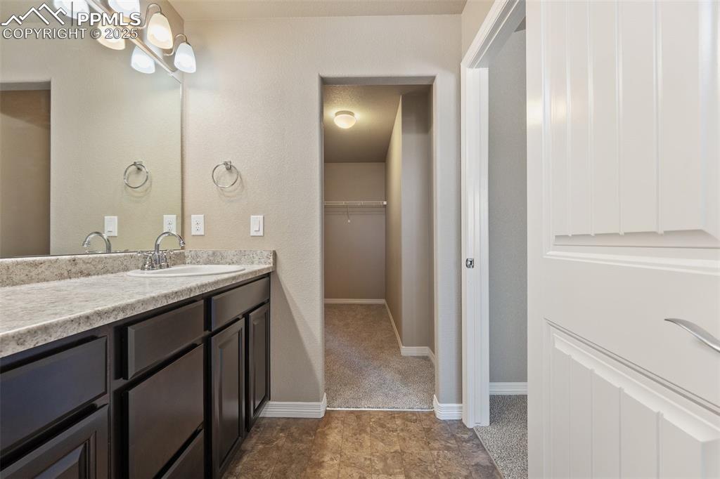 Image 16 of 25: Bathroom featuring vanity and a walk in closet