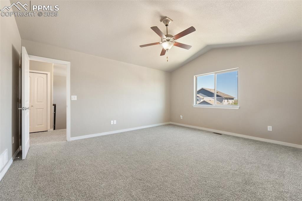 Image 17 of 25: Spare room with ceiling fan, light carpet, and vaulted ceiling