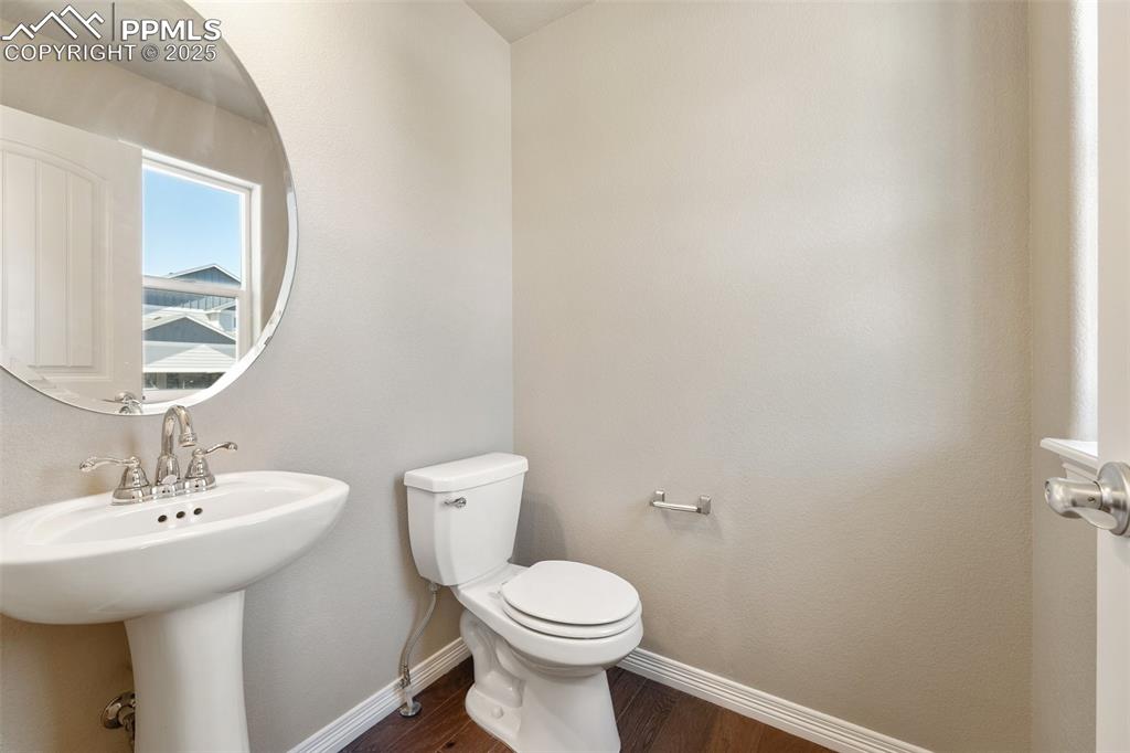 Image 20 of 25: Half bath featuring wood finished floors and toilet