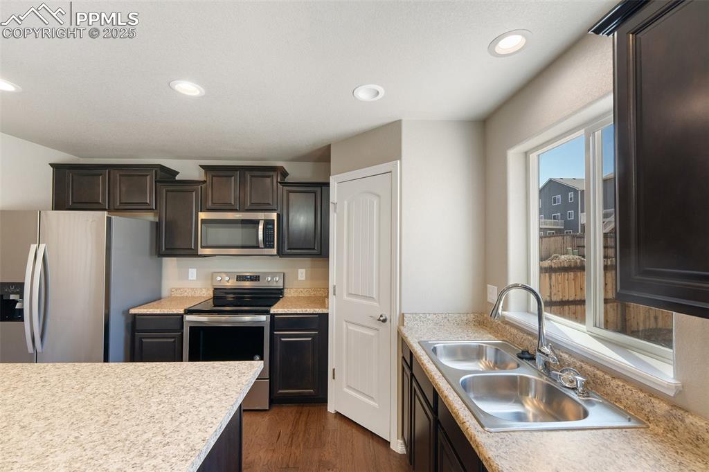 Image 23 of 25: Kitchen featuring appliances with stainless steel finishes, light counterto