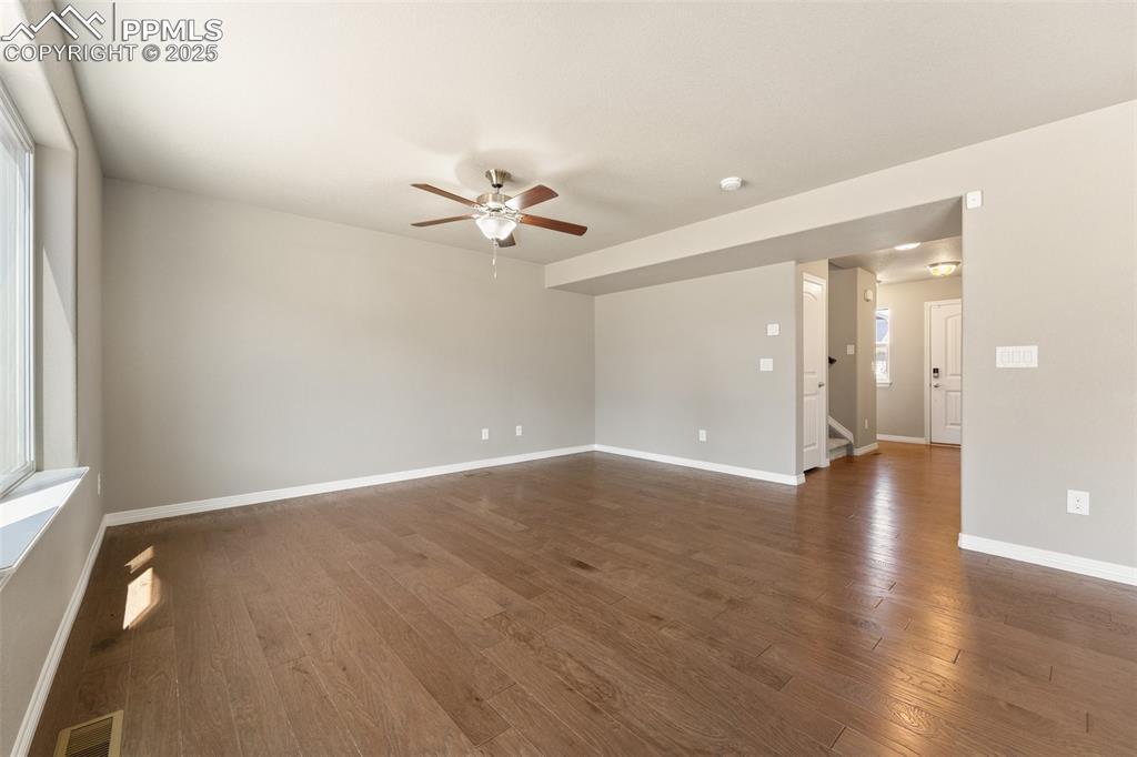 Image 4 of 25: Unfurnished room with ceiling fan, dark wood-type flooring, and a smoke det