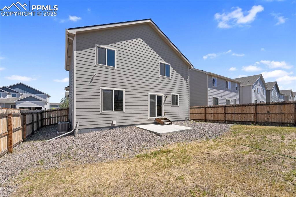 Image 6 of 25: Back of property featuring a patio area, a fenced backyard, and a residenti