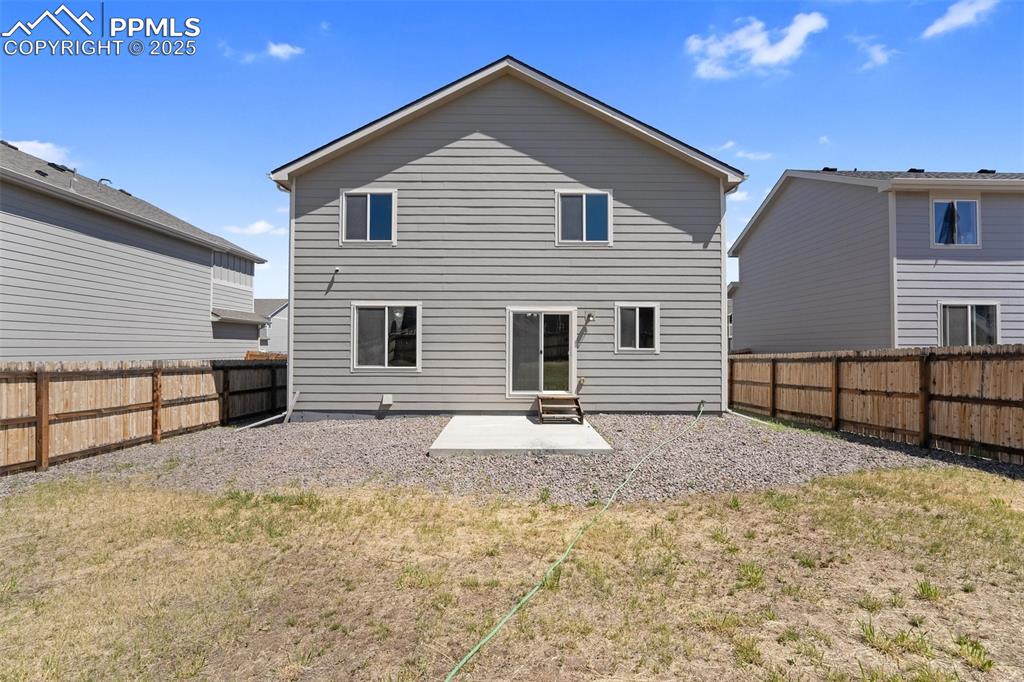 Image 7 of 25: Back of house featuring a patio area and a fenced backyard