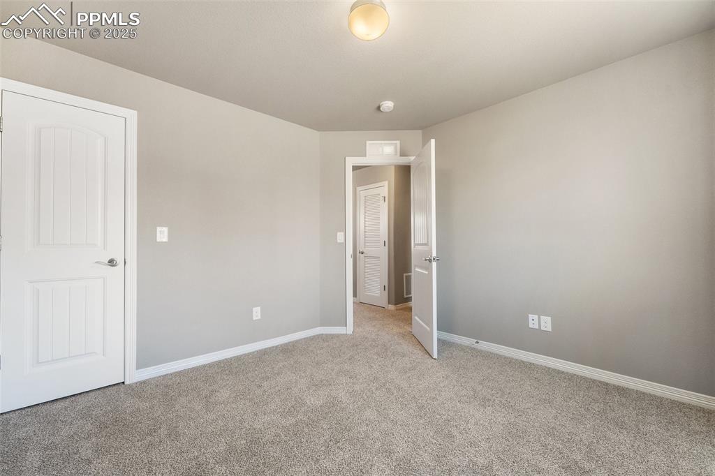 Image 9 of 25: Unfurnished bedroom with light carpet and baseboards