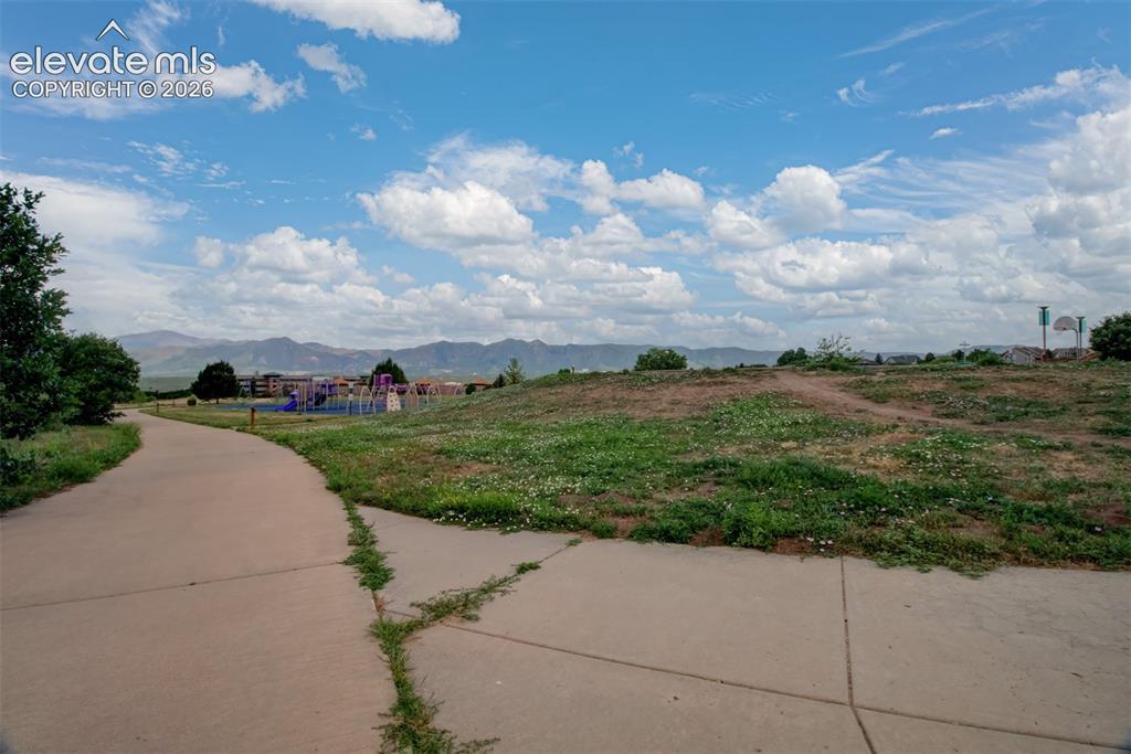 Image 43 of 47: View of mountains and elementary school from trail of open space