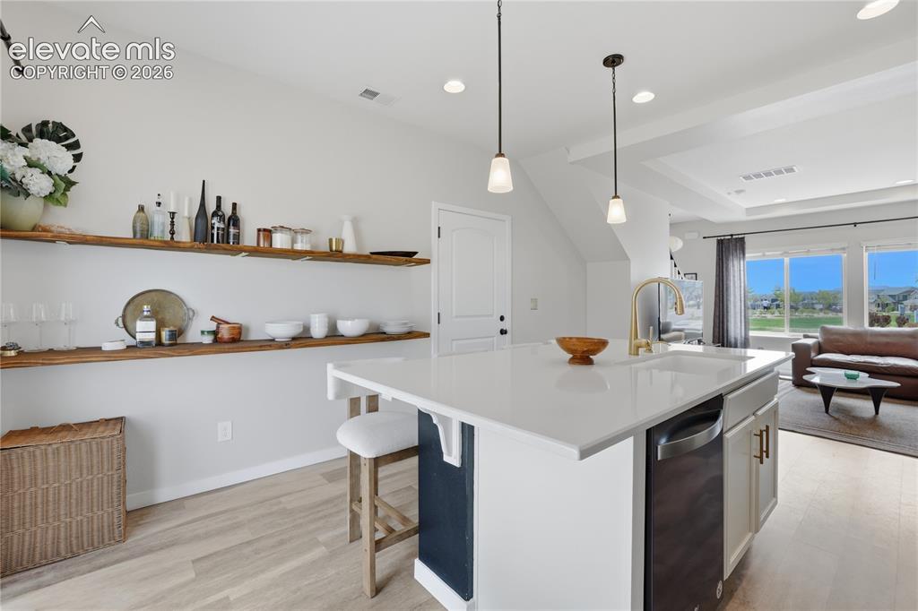 Image 14 of 48: Kitchen island featuring a white countertop, undermount sink, and brass-fin