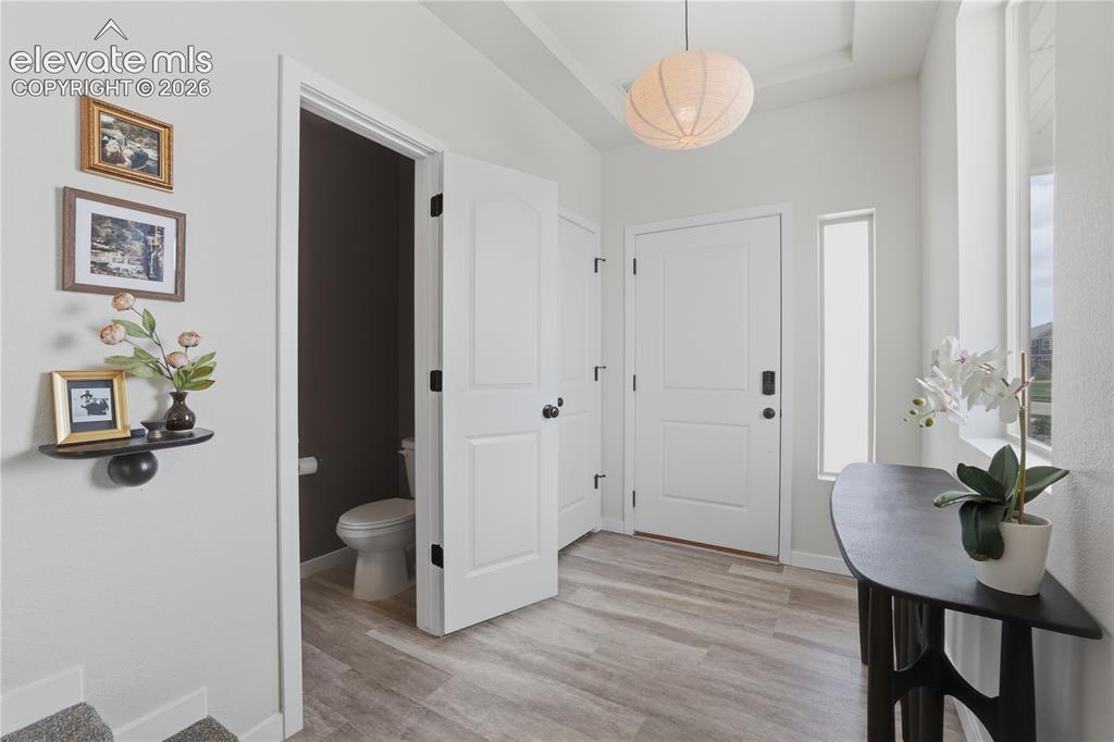 Image 16 of 48: Entryway featuring wood-finish flooring, a white paneled entry door, and a