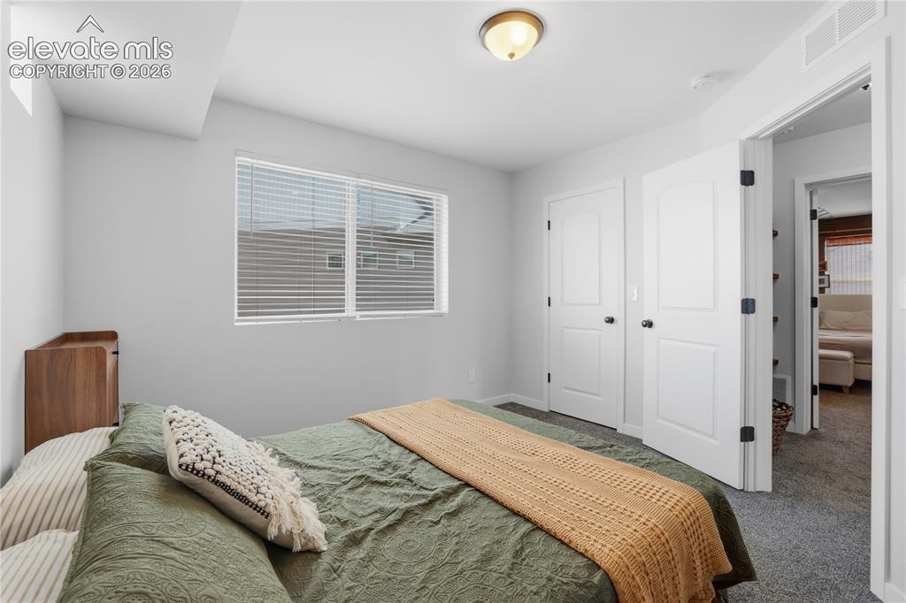 Image 27 of 48: Bedroom featuring light gray walls, white trim, and gray carpet