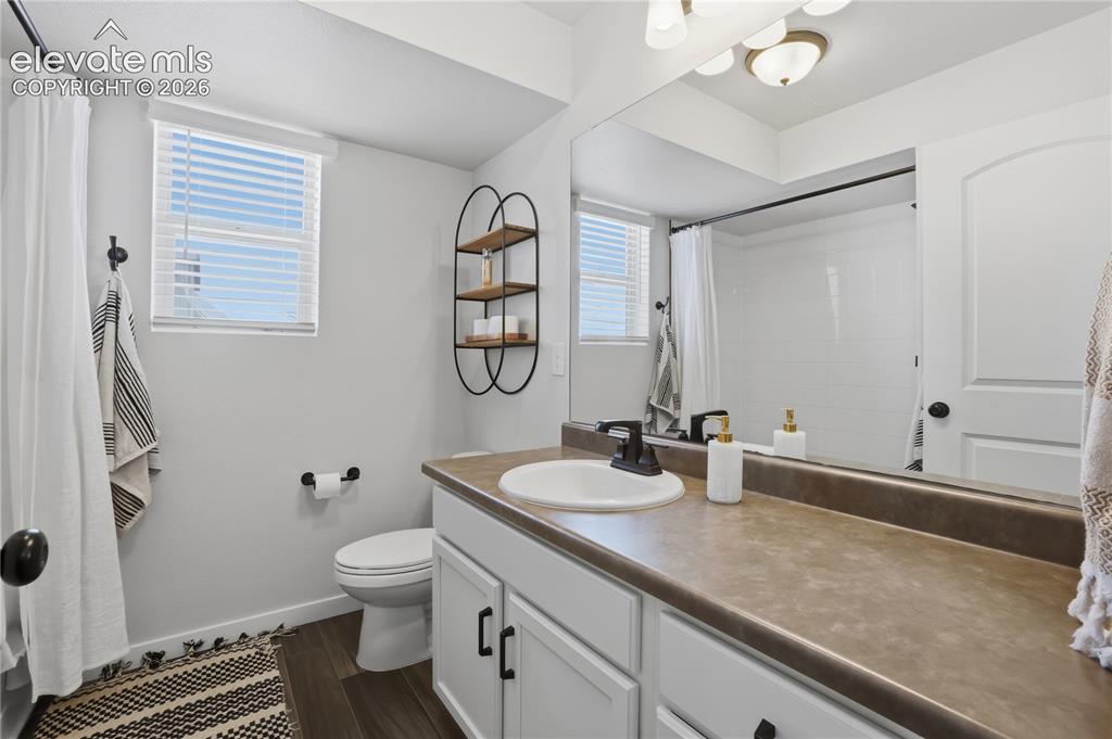 Image 28 of 48: Full bathroom featuring a single vanity with a white basin and dark counter