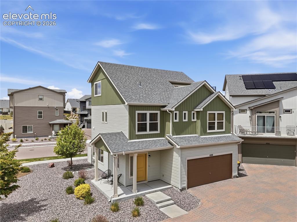 Image 3 of 48: Modern two-story residence featuring a striking green and beige exterior