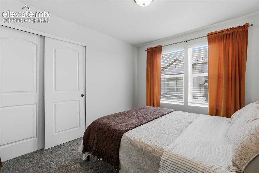 Image 30 of 48: Bedroom featuring carpet flooring, dual pane windows with blinds, and white