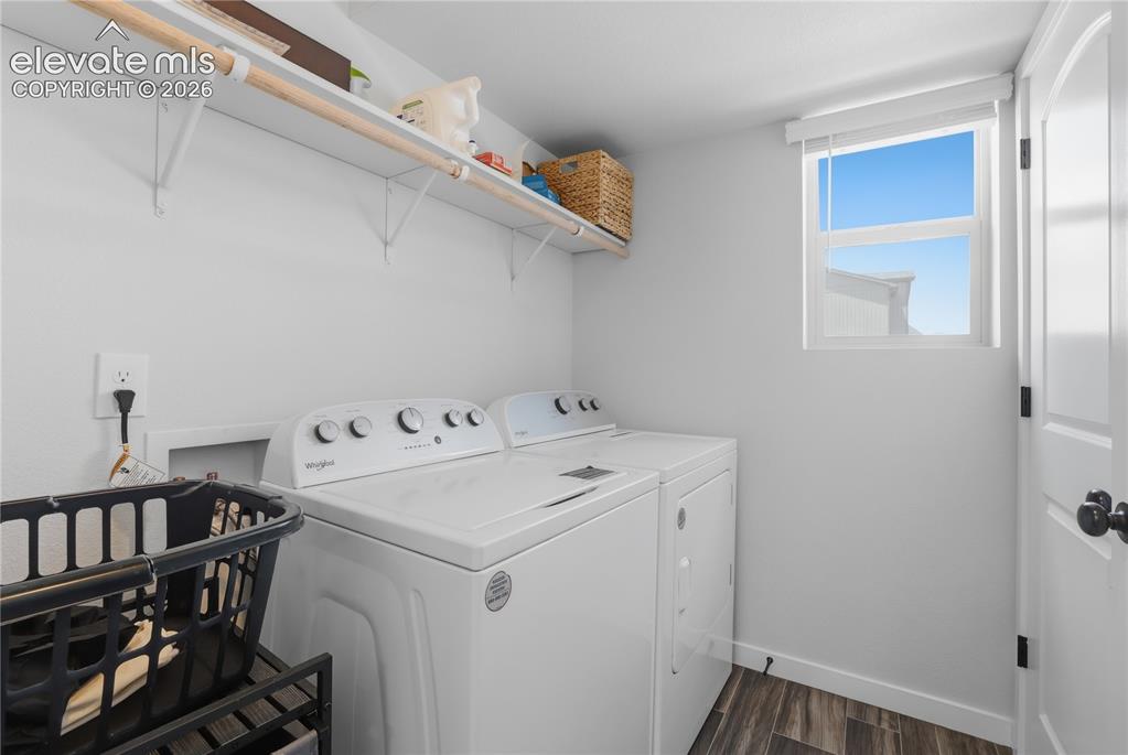 Image 32 of 48: Dedicated laundry space featuring wood-finish flooring, white walls, and a