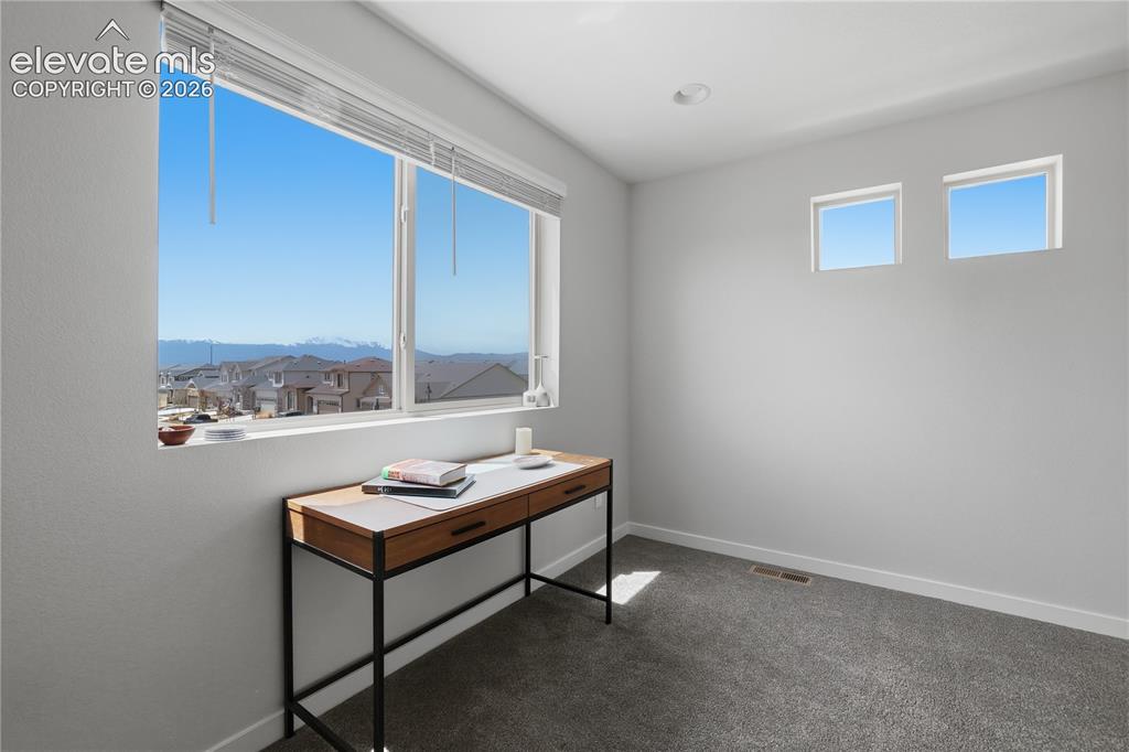 Image 37 of 48: Light gray interior walls with a large window featuring white blinds
