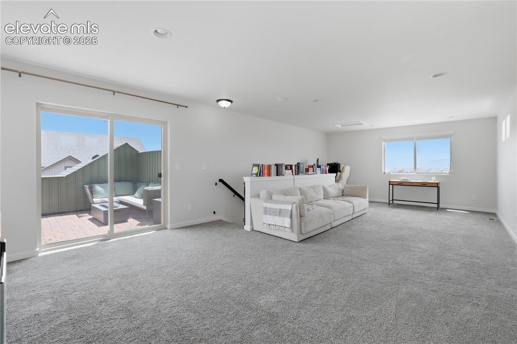 Image 38 of 48: Spacious loft area featuring light gray carpeting, recessed lighting, and a