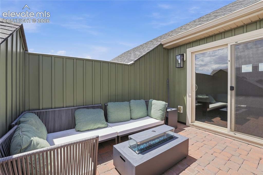 Image 39 of 48: Private rooftop patio featuring a built-in fire pit, privacy wall, outdoor