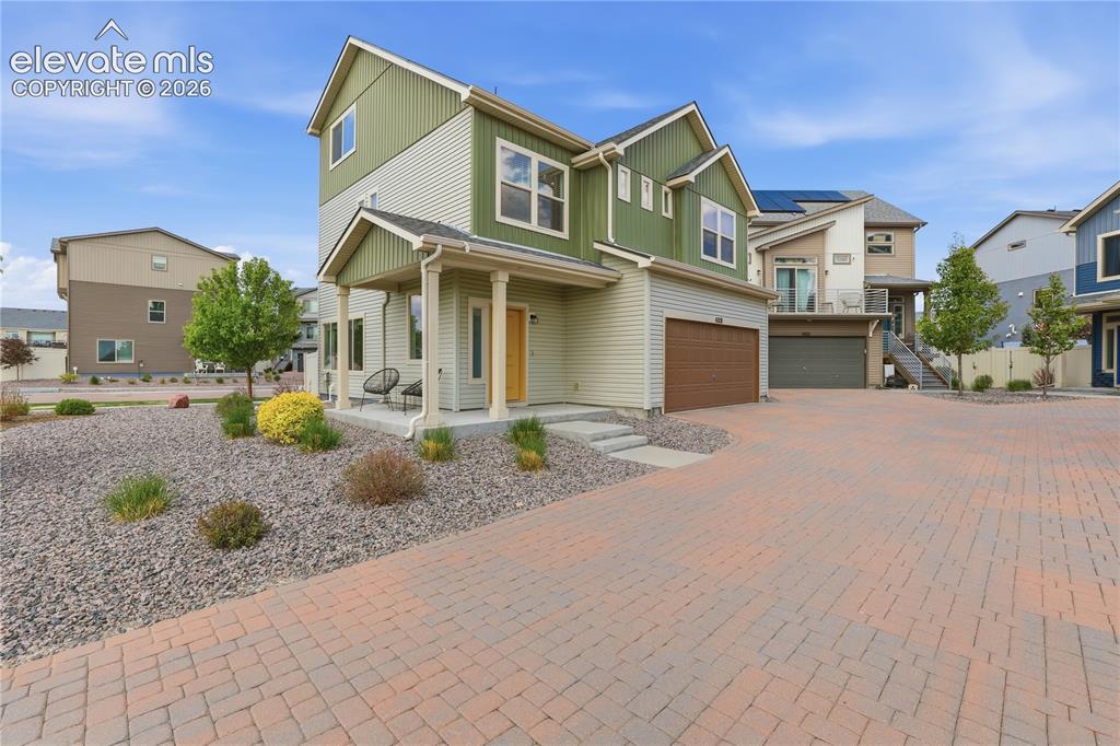 Image 4 of 48: Modern two-story residence featuring a covered porch with column supports,