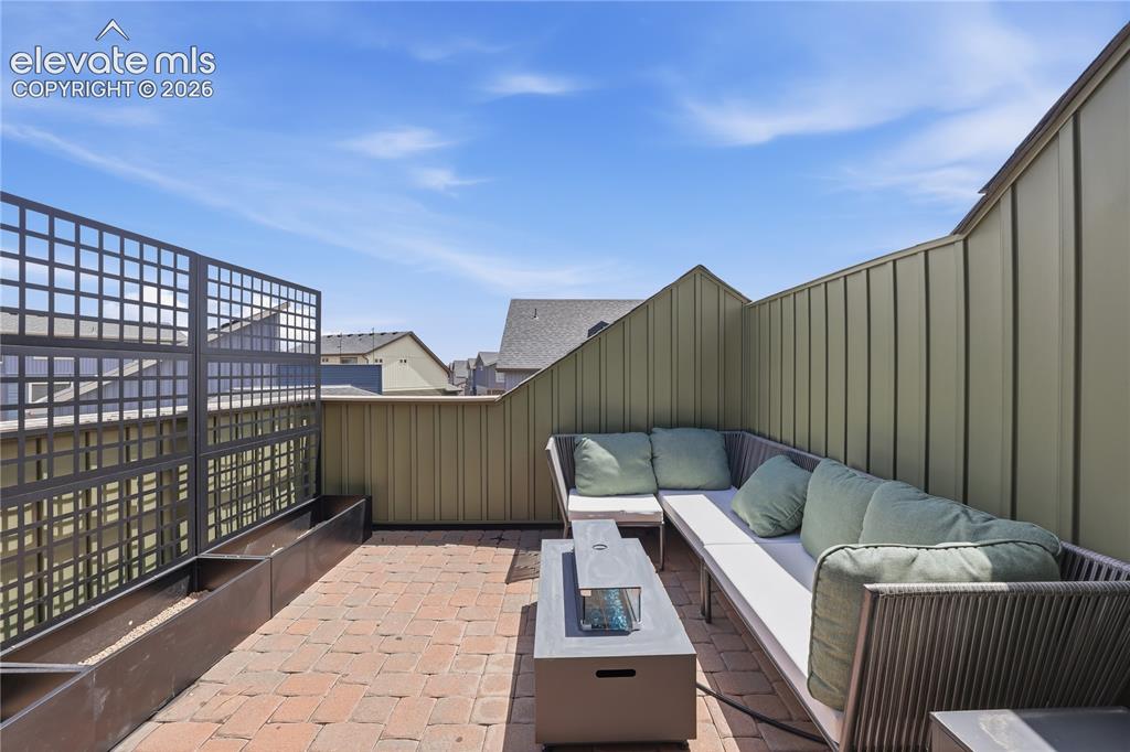 Image 42 of 48: Rooftop patio featuring brick paver flooring, a linear planter system, and