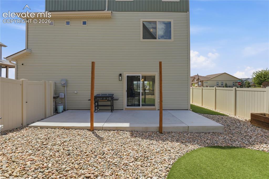 Image 44 of 48: Exterior patio featuring poured concrete, privacy fencing, gravel landscapi
