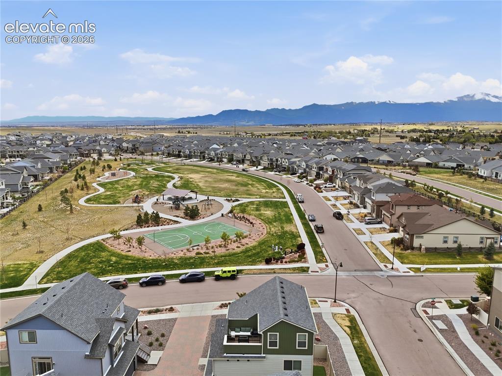 Image 48 of 48: Expansive community greenspace with a basketball court, walking paths, and