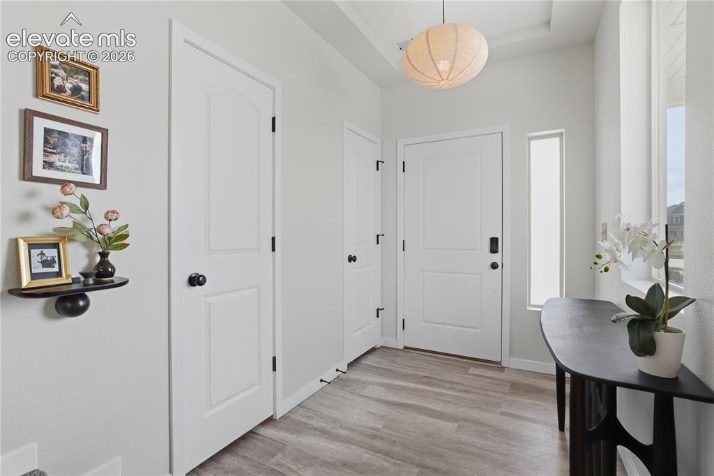 Image 6 of 48: Entryway featuring wood-finish flooring, a contemporary pendant light fixtu