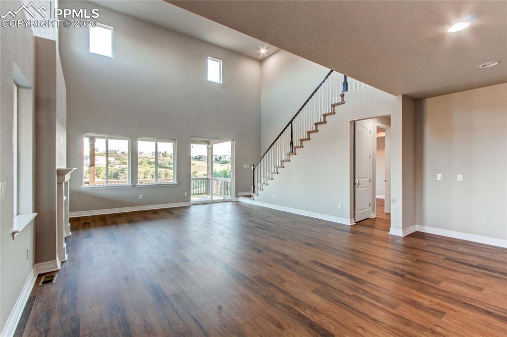 Image 21 of 49: Unfurnished living room with plenty of natural light, dark wood-style floor