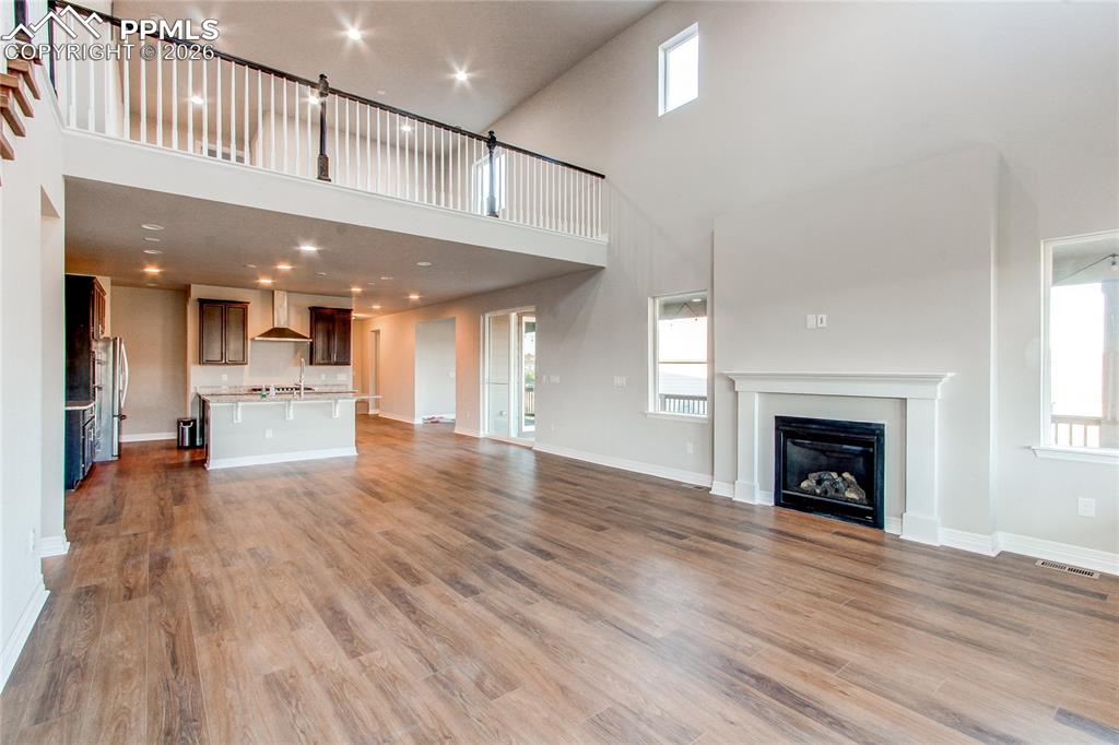Image 23 of 49: Unfurnished living room featuring a glass covered fireplace, recessed light