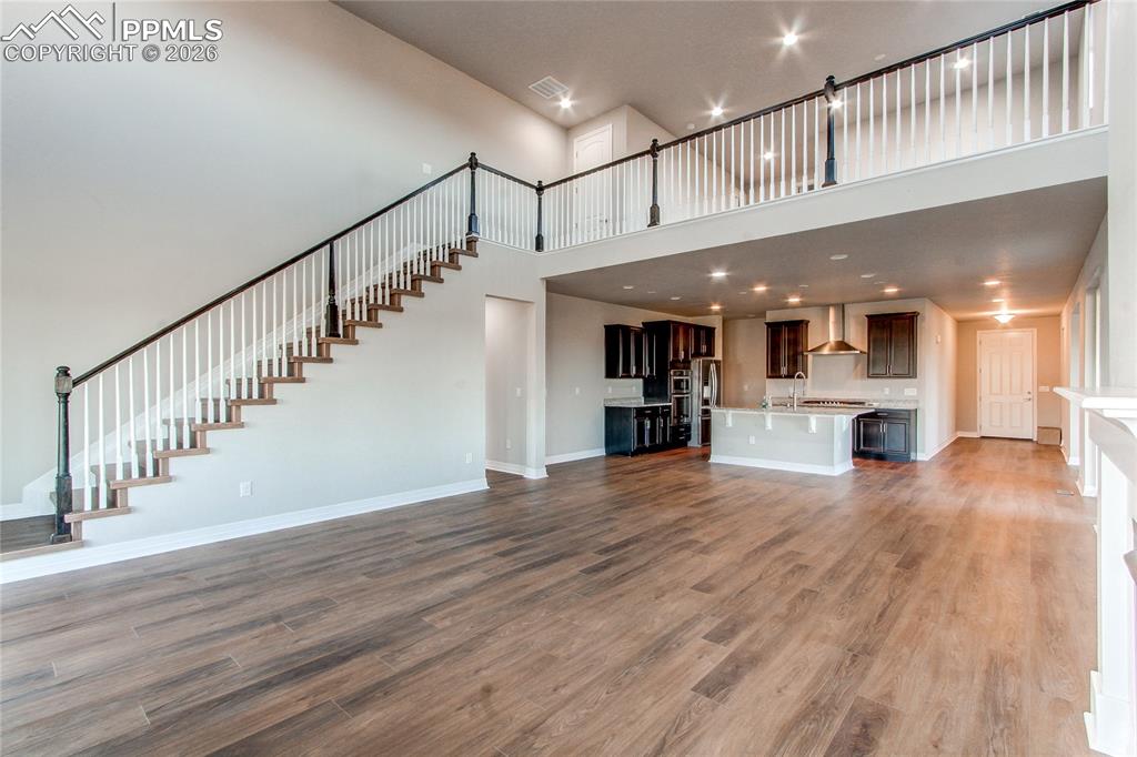 Image 24 of 49: Unfurnished living room featuring recessed lighting, dark wood-type floorin