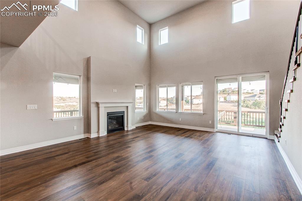 Image 26 of 49: Unfurnished living room with a glass covered fireplace, plenty of natural l