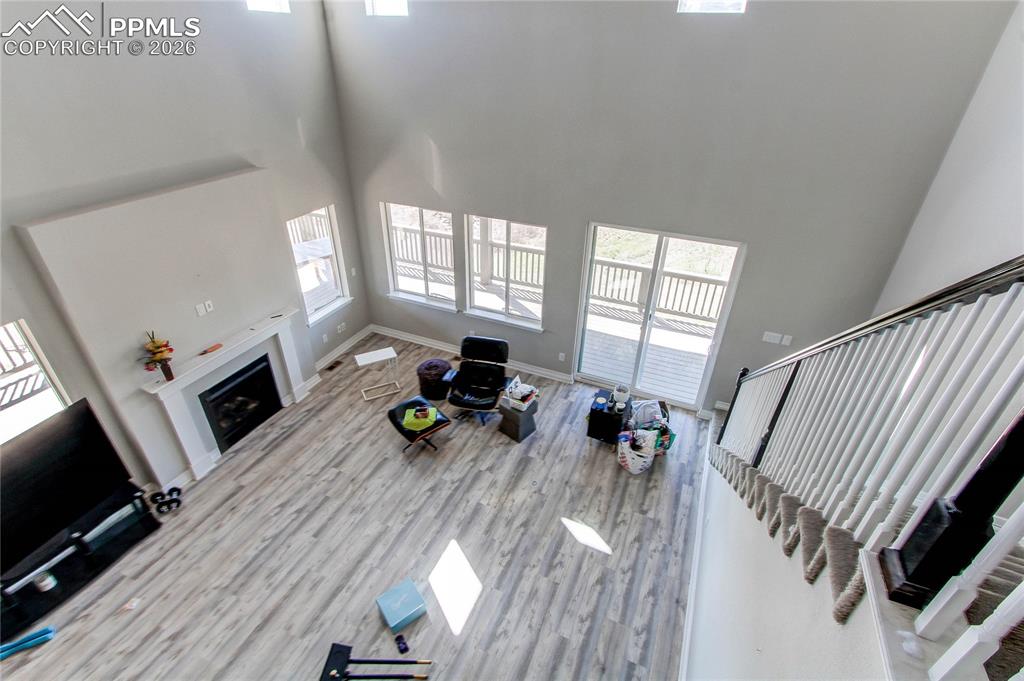 Image 29 of 49: Unfurnished living room with a high ceiling, a fireplace, and light wood fi