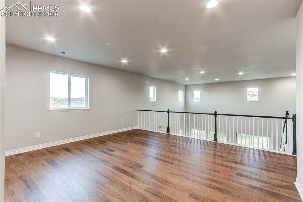 Image 36 of 49: Spare room with wood finished floors, healthy amount of natural light, and 