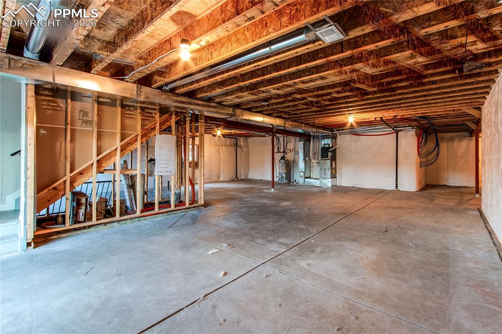 Image 48 of 49: Unfinished below grade area featuring water heater