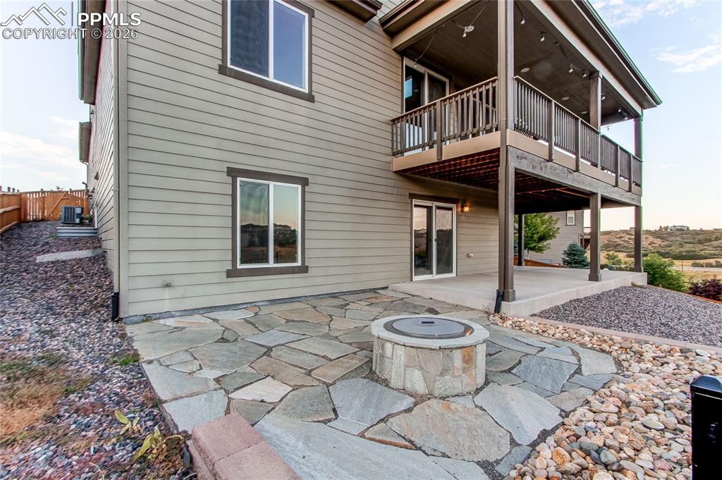 Image 7 of 49: Back of house featuring a patio, a fire pit, and a wooden deck