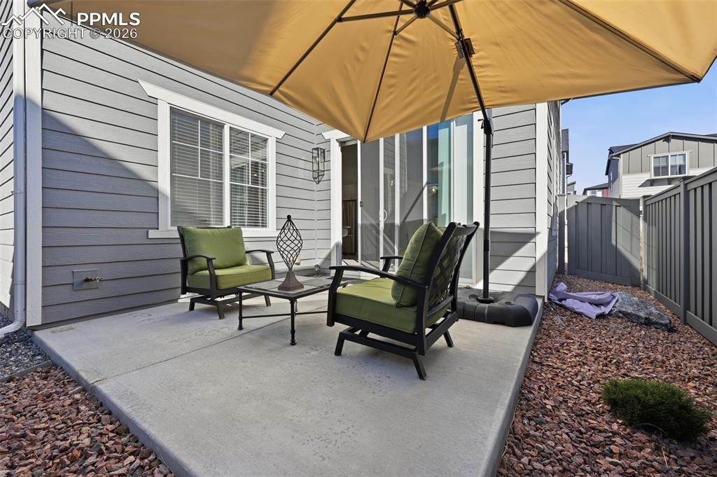 Image 28 of 32: Concrete back patio with xeroscaping