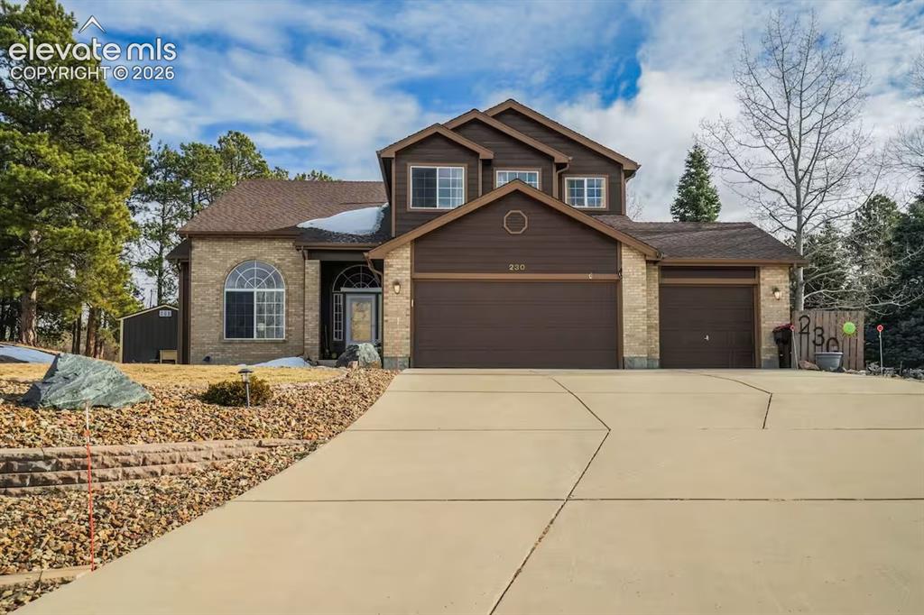 Image 1 of 45: Two-story residence featuring brick and siding facade, a three-car garage,
