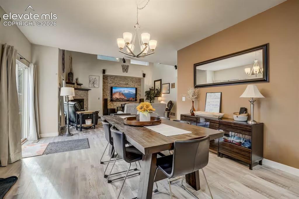 Image 12 of 45: Dining area featuring wood-finish flooring, a contemporary chandelier, and