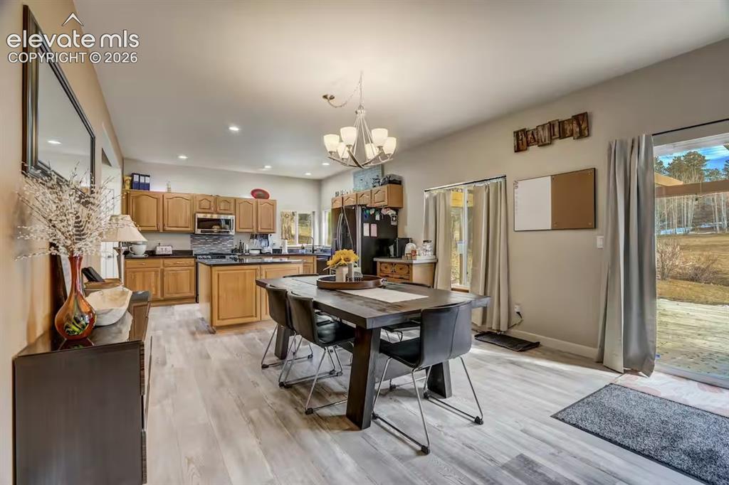 Image 13 of 45: Open-concept kitchen and dining area featuring wood-finish flooring