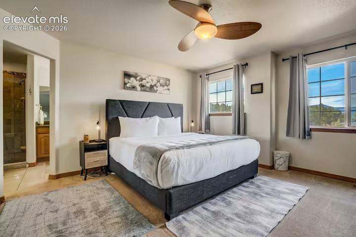 Image 14 of 45: Bedroom featuring a vaulted ceiling with a wood-finish ceiling fan, two win
