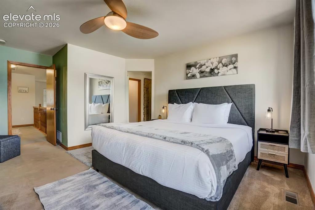 Image 15 of 45: Carpeted bedroom featuring a ceiling fan with integrated lighting, a full-l