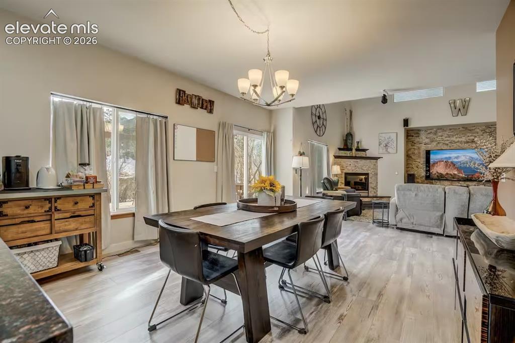 Image 20 of 45: Open-concept living space featuring wood-finish flooring, a contemporary ch