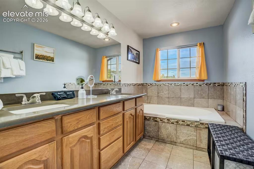 Image 23 of 45: Dual vanity with a stone-finish countertop, undermount sinks, and ample woo