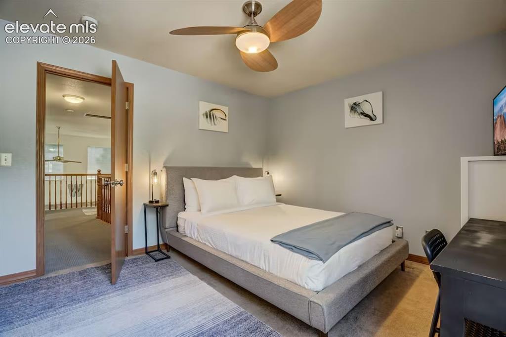 Image 27 of 45: Bedroom featuring light gray walls, wood-finish door frames, a contemporary