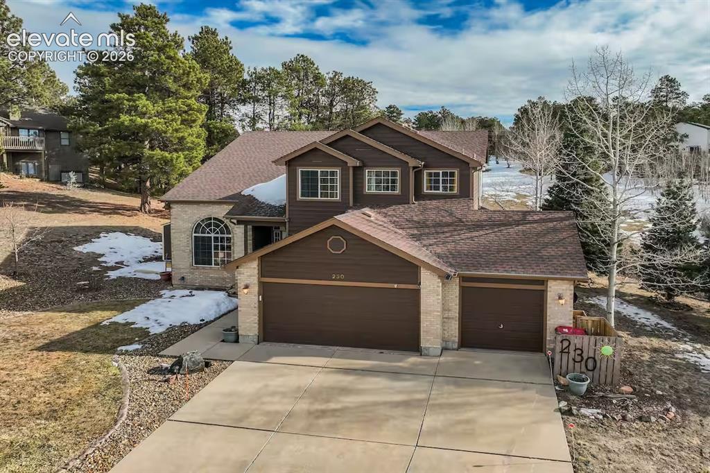 Image 3 of 45: Two-story residence featuring a two-car garage, brick and siding exterior,
