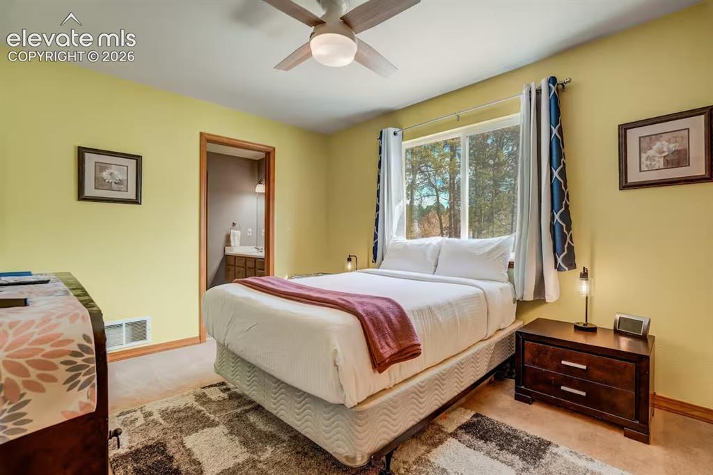 Image 31 of 45: Bedroom featuring a ceiling fan, a window with outdoor scenery, and light-c