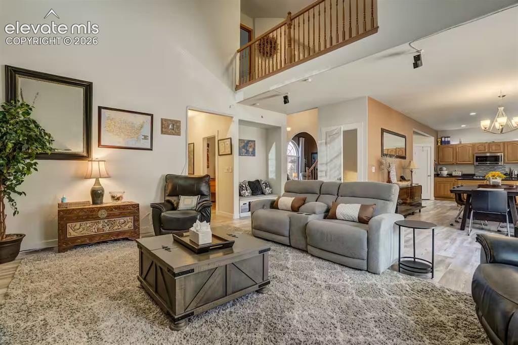 Image 32 of 45: Spacious living area featuring high ceilings, a second-story balcony, light