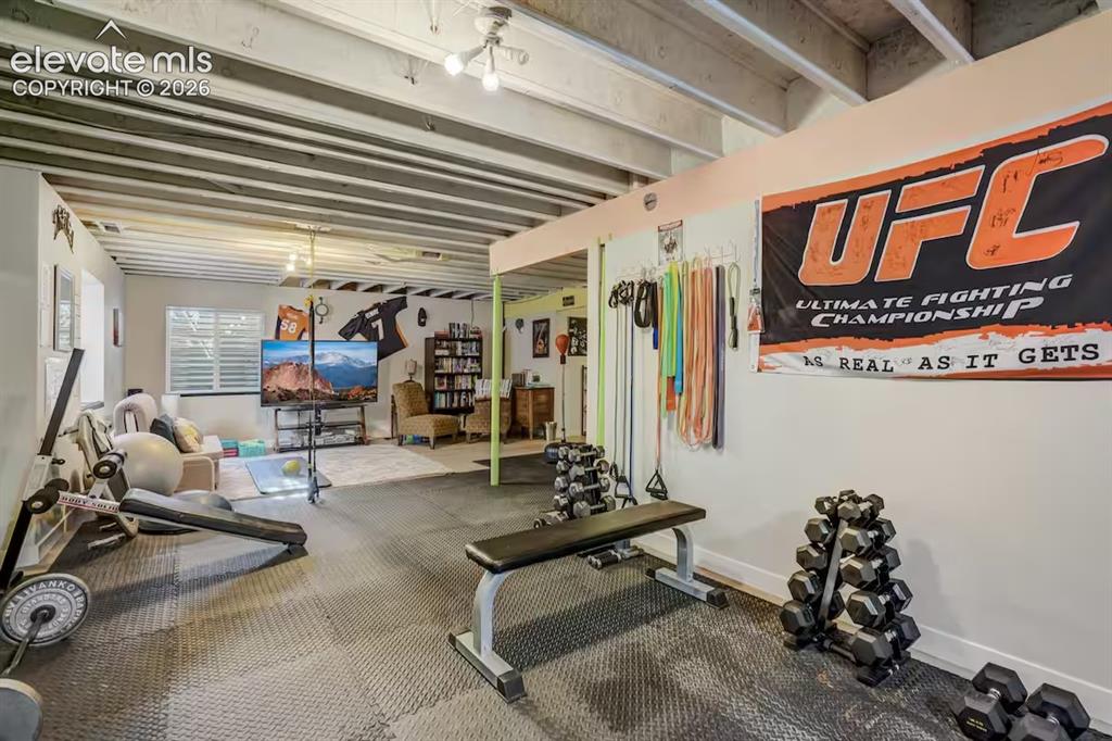 Image 36 of 45: Spacious lower-level area featuring exposed ceiling joists, durable floor m