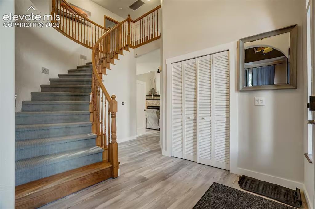Image 4 of 45: Curved staircase with wood railing, carpeted treads, and wood-finish floori