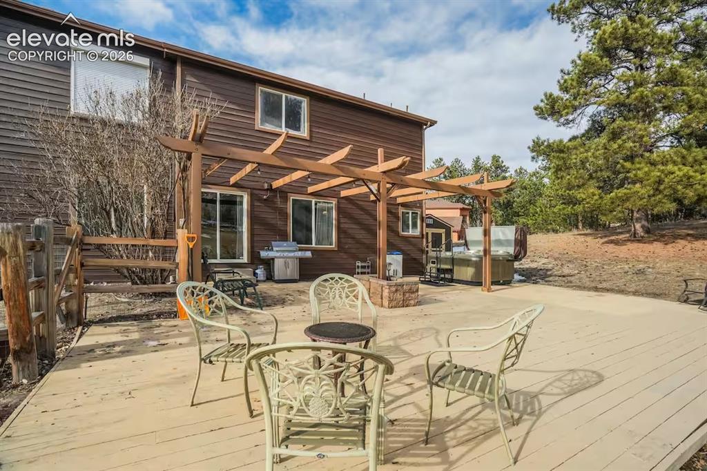 Image 41 of 45: Expansive exterior deck featuring a pergola, wood-finish siding, and multip
