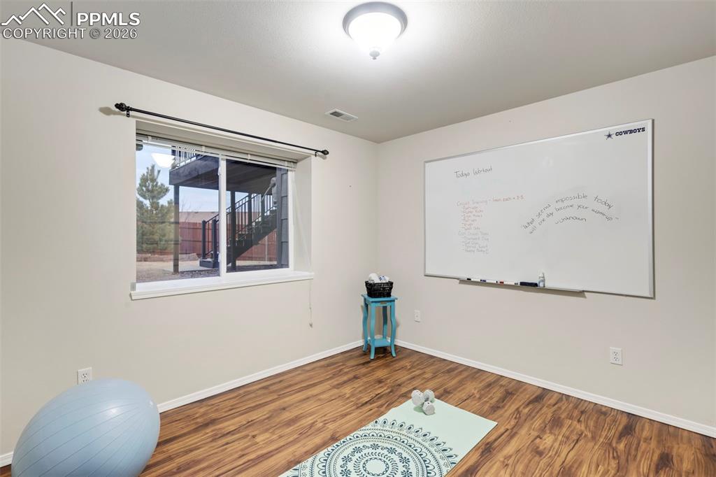 Image 34 of 50: Exercise room with wood finished floors