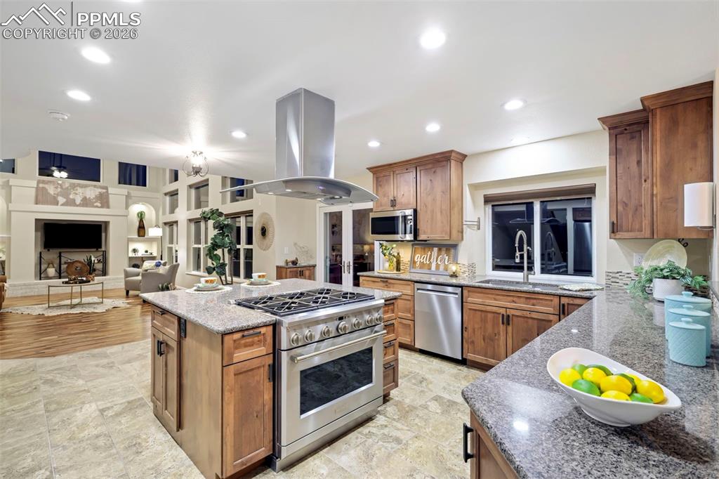 Image 9 of 50: Kitchen with light stone counters, stainless steel appliances, wood finish 